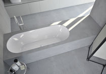 Oval bathtub / Corian® / resin / marble