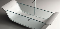 Free-standing bathtub / Corian® / glass