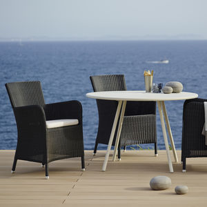 contemporary chair / with armrests / with removable cushion / wicker