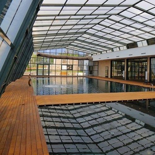 High swimming pool enclosure - EVOLUTION LEAN-TO - Evergreen Solutions - wall / retractable / aluminum