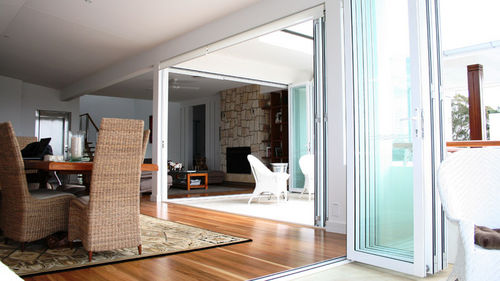 Sliding and stacking patio door - GENESIS - Capral Aluminium - folding / aluminum / double-glazed