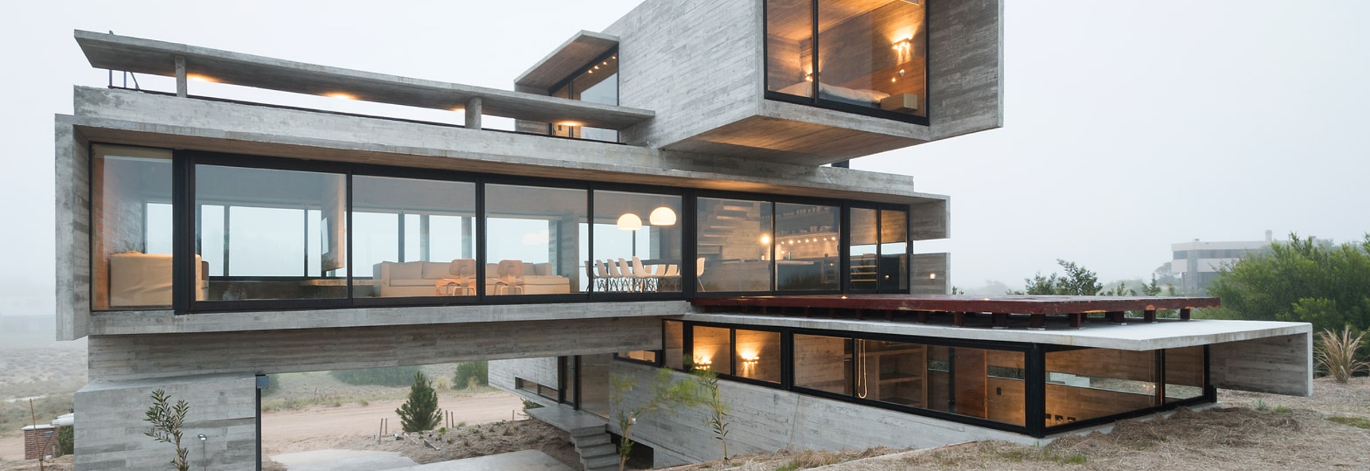 Board-marked concrete house by Luciano Kruk stands on a seaside golf ...