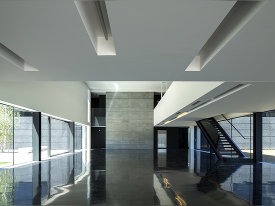 the entrance hall has a black terrazzo floor that connects both courtyards