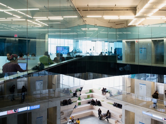 a reception area is defined by a spacious atrium that houses informal seating areas