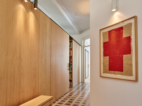 Built Architecture uses oak cabinetry to reorganise a mosaic-floored Barcelona apartment