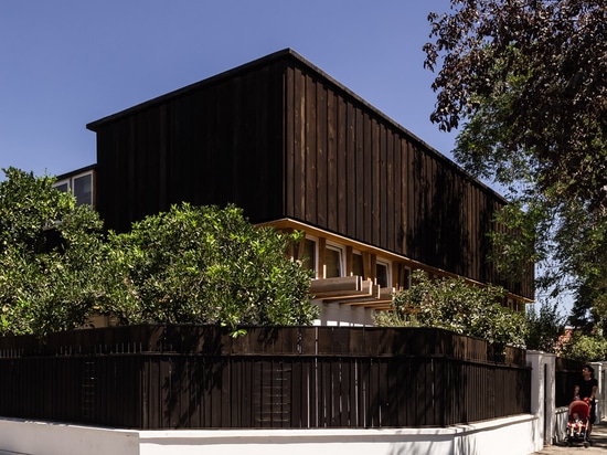 DX Arquitectos extends yoga teacher's house with a blackened timber studio on top