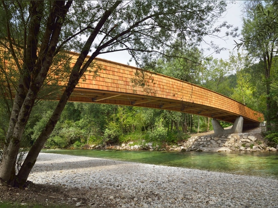 Arching wooden footbridge by DANS Architects connects Slovenian village to mountains