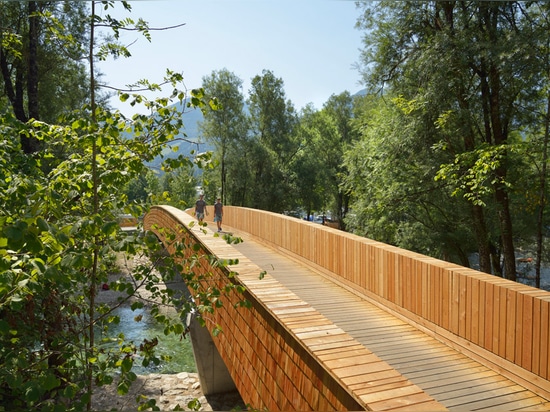 Arching wooden footbridge by DANS Architects connects Slovenian village to mountains