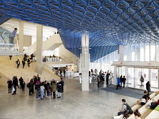 The platform is sheltered by a sloping canopy clad in iridescent, hand-folded metal panels that stretches from the exterior façade into the lobby. Photography: Lorne Bridgman