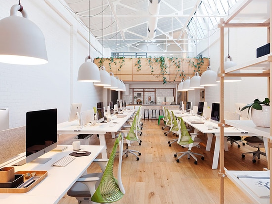 long white tables establish the layout of the open plan space with a kitchen at the rear