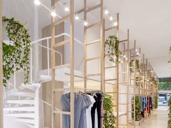 a mirror placed at the end of the store’s linear plan doubles the visual experience