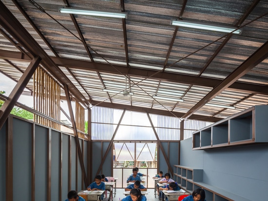 the lifted and inclined roof allows light and air flow into the classrooms