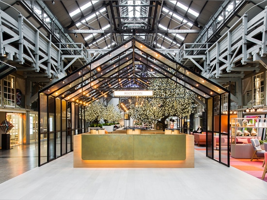 the hotel reception sits underneath a lit house-shaped pavilion