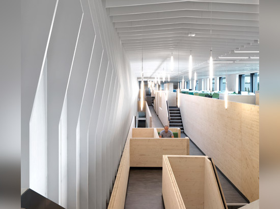 Multi-level wooden structure frames meeting areas in London office by Threefold Architects