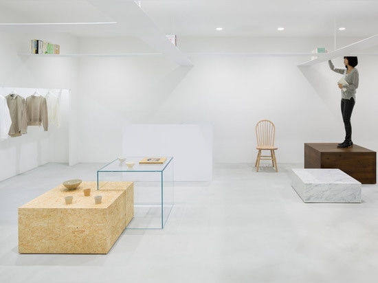 Nendo's grid of suspended bookshelves hangs above shoppers in Beige fashion boutique