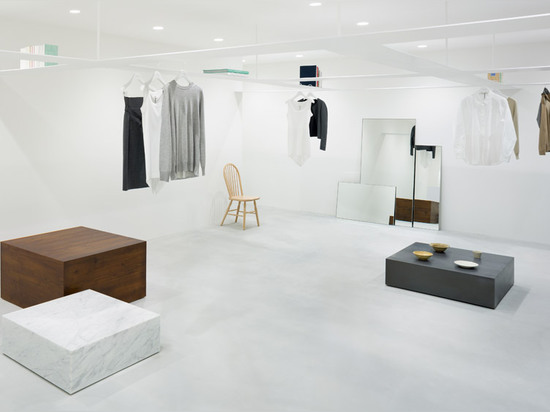 Nendo's grid of suspended bookshelves hangs above shoppers in Beige fashion boutique