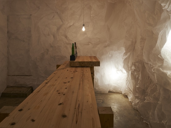 Crumpled paper transforms a gallery into grotto-like Yorunoma bar in Japan