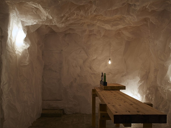 Crumpled paper transforms a gallery into grotto-like Yorunoma bar in Japan