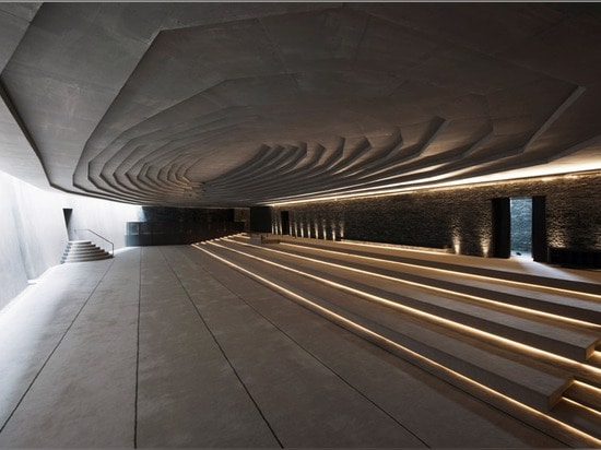 Terraced landscaping surrounds concrete and stone structure of Emre Arolat's Sancaklar Mosque