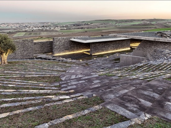 Terraced landscaping surrounds concrete and stone structure of Emre Arolat's Sancaklar Mosque