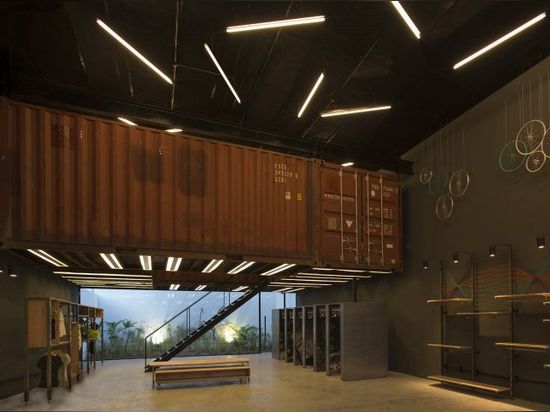 Shipping containers are suspended above shoppers inside Le Utthe boutique