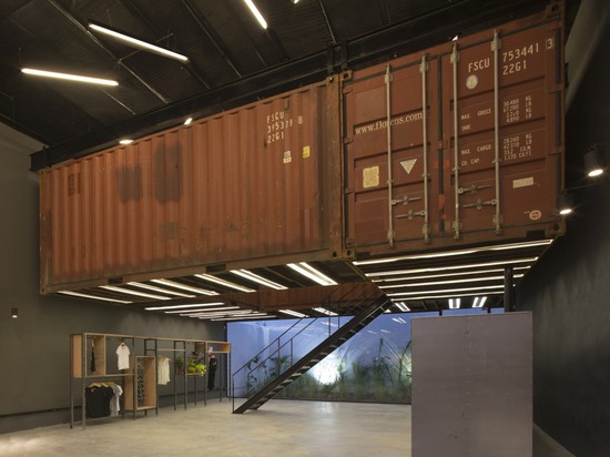 Shipping containers are suspended above shoppers inside Le Utthe boutique