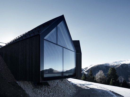 Stunning wooden Oberholz Mountain Hut branches out of the mountainside like a fallen tree