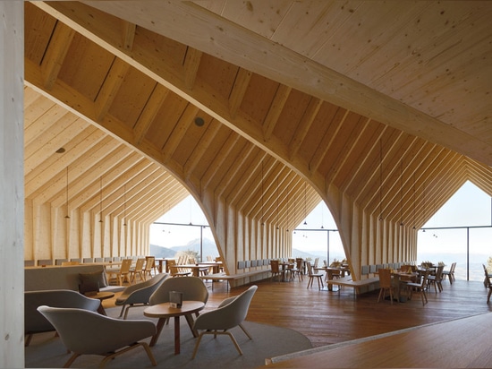 Stunning wooden Oberholz Mountain Hut branches out of the mountainside like a fallen tree