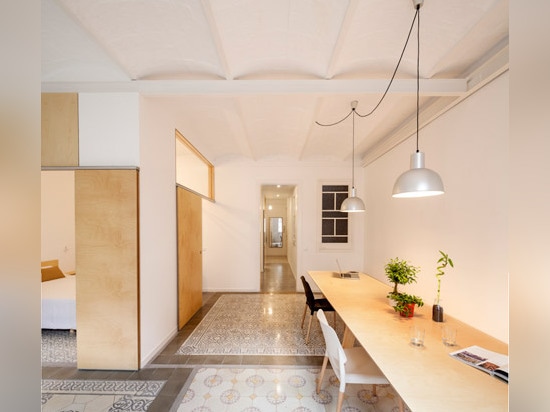 Sliding chipboard units create multifunctional space in Madrid apartment