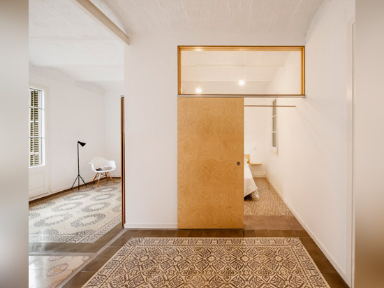 Sliding chipboard units create multifunctional space in Madrid apartment