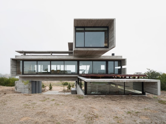 Board-marked concrete house by Luciano Kruk stands on a seaside golf course