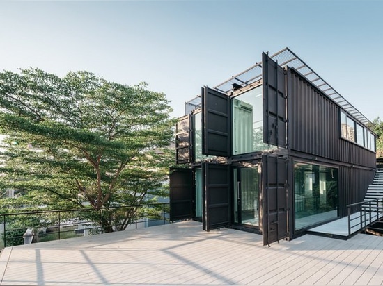 archimontage stacks shipping containers to form 'carcare' center in bangkok