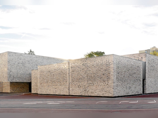 The new brick facade wraps around the preexisting concrete structure built in the 1970s. (Luc Boegly)