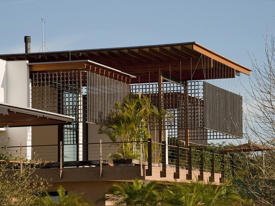 A wood lattice filters the sun, but not the views from this house in Brazil