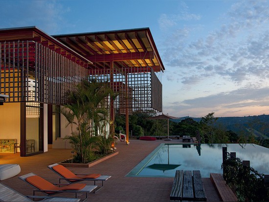 A wood lattice filters the sun, but not the views from this house in Brazil