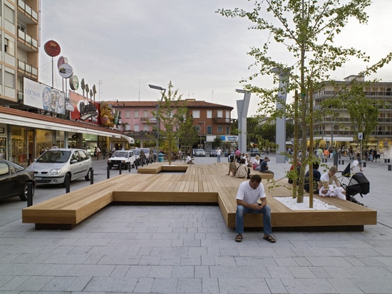 A Large Bench Serves As A Gathering Place In This Town Square