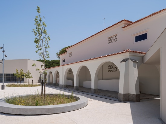 Circular holes connect playgrounds on two levels of a Lisbon school