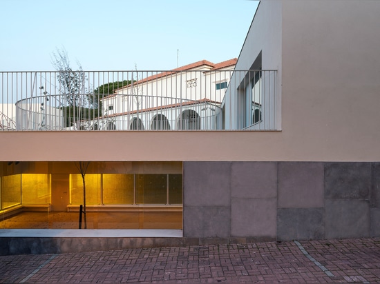 Circular holes connect playgrounds on two levels of a Lisbon school