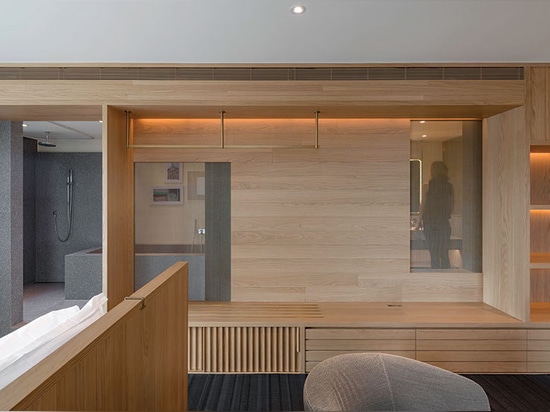 An oak storage wall in one suite is pierced by screens to provide “voyeuristic” views into the bathroom.