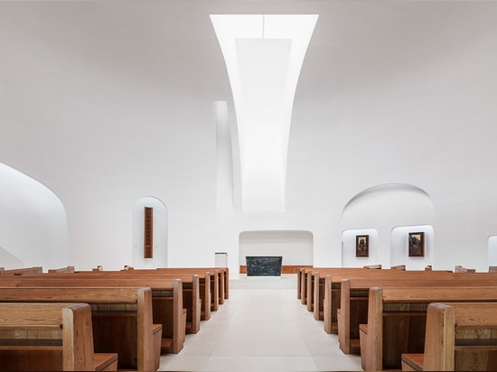 The church interior features whitewashed reinforced concrete ceilings and walls