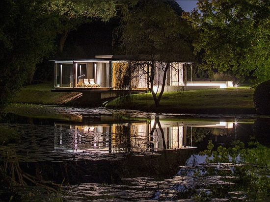 Gorgeous Miesian-inspired glass pavilion floats above a natural dam