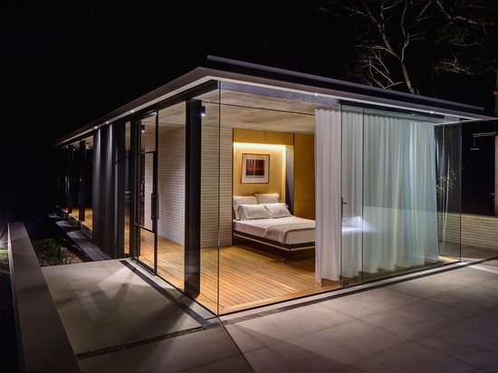 The interior spaces include a sunken spa and living room on the cantilevered end; a bathroom, kitchen, and storage space in the middle; and a bedroom with a folding bed on the opposite end.   Read ...