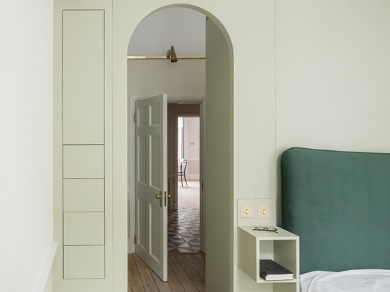 The bedroom has been finished with a green headboard and side tables