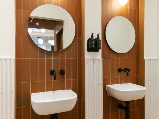 More arched niches appear in the cafe's bathrooms, which are lined with terracotta tiles