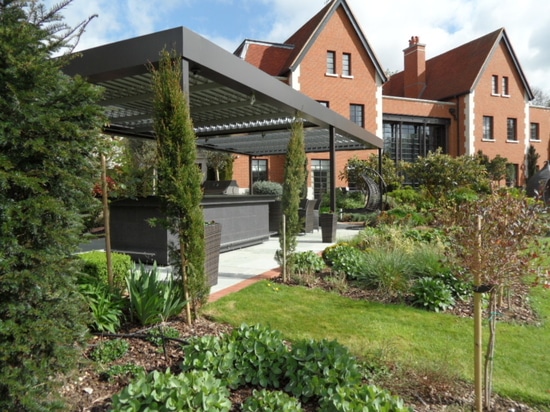 Outdoor living room with bioclimatic pergola  in a country house in England