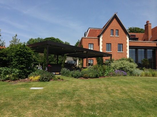 Outdoor living room with bioclimatic pergola  in a country house in England