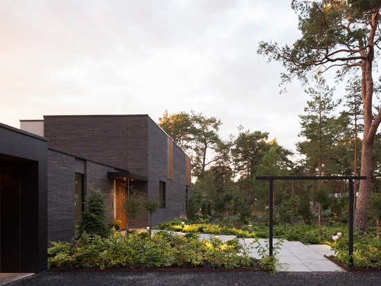 The dark bricks help the house to blend with its setting