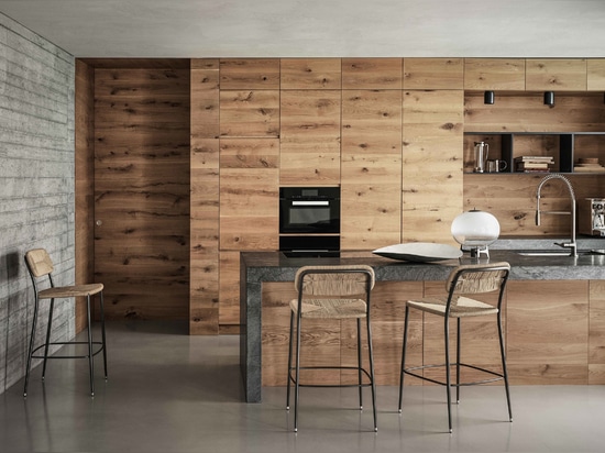 The kitchen features oak cabinets and an L-shaped counter