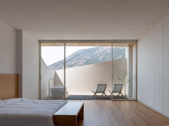 Floor-to-ceiling windows frame views across the mountains