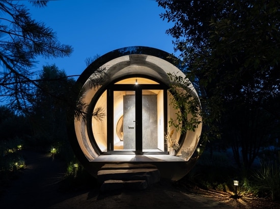 This Tube-Shaped Cabin With A Polished Metal Exterior Hovers Over The Surrounding Landscape